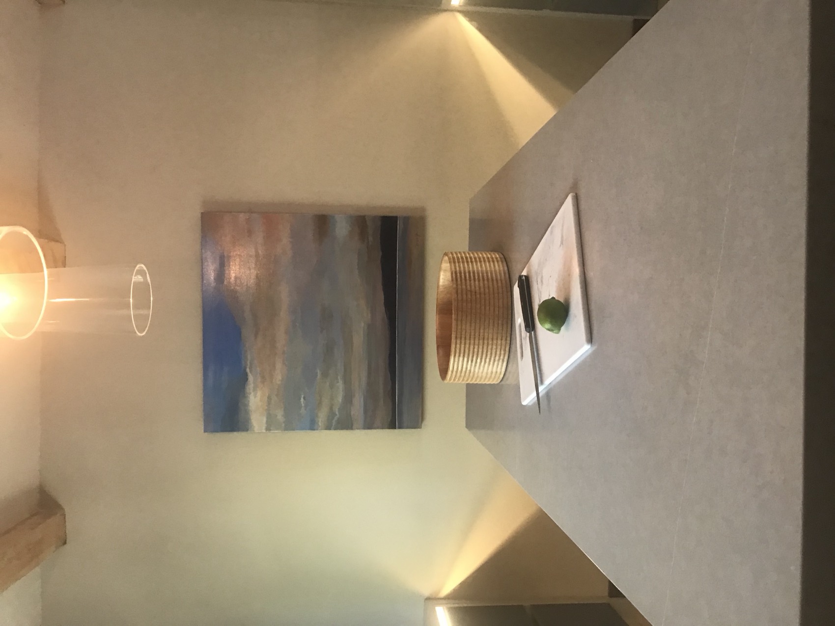 Calm dining nook with a seascape painting and warm wood table