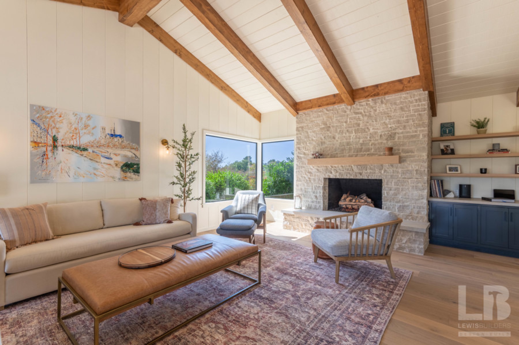 Great room with stone fireplace and ocean view through corner glass